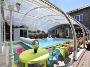 a patio with a pool with a table and chairs at Pleasant Holiday Home with Sauna and Jacuzzi in Courtil in Gouvy