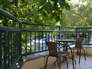 2 sillas y una mesa en un balcón con árboles en Villa K Apartments, en Belgrado