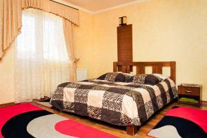 a bedroom with a bed and a window and two rugs at Filvarok Hotel in Brody