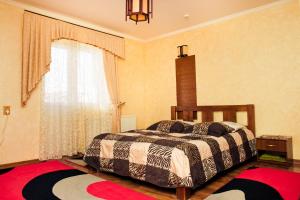 Schlafzimmer mit einem Bett und einem Fenster in der Unterkunft Filvarok Hotel in Brody