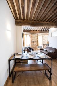 een woonkamer met een tafel en een bank bij Le St Pierre - Style et Caractère à 10min du Vieux Lyon in Lyon