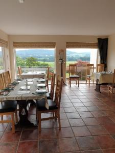 - une salle à manger avec une table, des chaises et des fenêtres dans l'établissement the old red lion, à Bruton