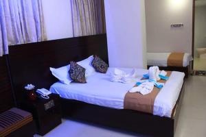 Una habitación de hotel con una cama con toallas. en Royal Palm Hotel, en Sylhet