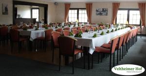 a large room with a long table and chairs at Landgasthaus Veltheimer Hof in Porta Westfalica