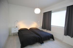 a bedroom with a bed with a large window at KOLMIO SAUNALLA in Kokkola