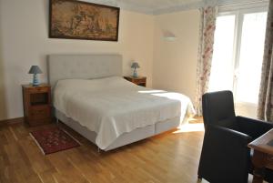 a bedroom with a white bed and a chair at Grand Tamaris Hosting in Arles