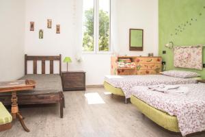 1 Schlafzimmer mit 2 Betten, einem Tisch und einem Fenster in der Unterkunft A Casa Fachin Room & Breakfast in Bologna