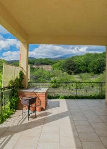 a patio with a grill and a table on a balcony at Le Vigne - Villa overlooking Etna in Adrano