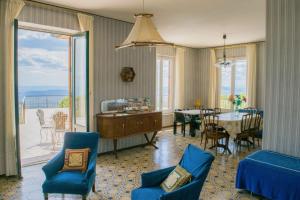 a living room with a table and chairs and a dining room at Le Vigne - Villa overlooking Etna in Adrano