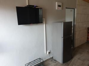 a black refrigerator with a flat screen tv on the wall at 100 on Girvan in Durban