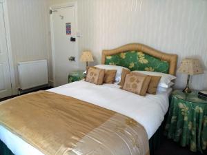 - une chambre avec un grand lit blanc et deux lampes dans l'établissement Bay Tree House Southport, United Kingdom, à Southport