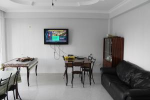 a living room with a table and a tv on the wall at KUKARACHA in Ureki