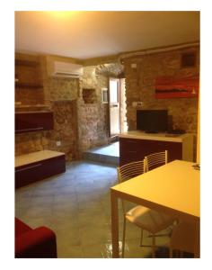 a kitchen with a table and chairs in a room at Accogliente monolocale in Isola del Giglio