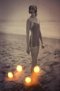 kobieta stojąca na plaży ze światłami w wodzie w obiekcie Monte Cassino Apartments w mieście Sopot