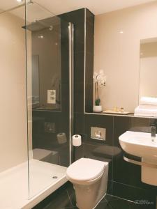 Un baño con ducha, inodoro y lavabo. en Homely Serviced Apartments - Blonk St, en Sheffield 28 fotos más