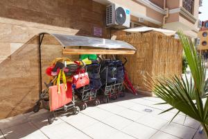 a cart full of bags and shopping bags next to a wall at Feniks Apartments in Nesebar