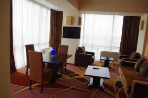 a hotel room with a table and chairs and a couch at Mari Vila Hotel in Bucharest