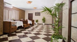 un restaurante con mesa, sillas y plantas en Grand Sport Hotel, en Brovary