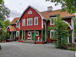 a red house with a green door at Stockholm B&B Cottage in Nacka