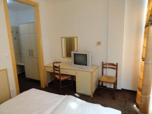a bedroom with a desk with a tv and two chairs at Rooms K in Maribor