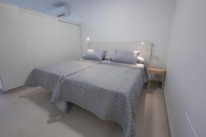 1 cama con 2 almohadas azules en una habitación en Apartamentos Mombasa 1 Planta, en Nerja