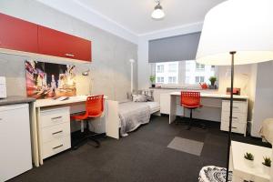 ein Wohnzimmer mit einem Schreibtisch und einem Sofa in der Unterkunft Salsa Hostel Premium in Łódź