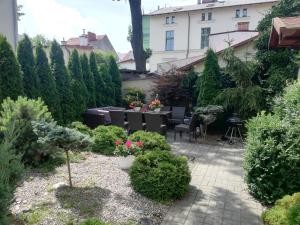 un jardín con mesa, sillas y plantas en blatoapartament en Sopot