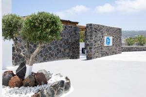 un árbol y rocas delante de un edificio en June Twenty Suites, en Karterados