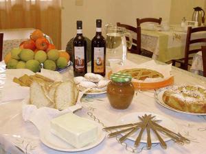 einen Tisch mit Brot und Flaschen Wein und Essen in der Unterkunft Agriturismo Le Frasche in Alberese