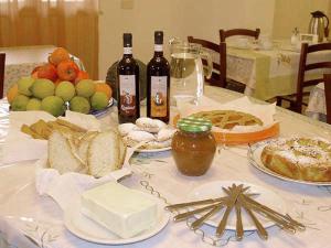 a table with bread and bottles of wine and food at Agriturismo Le Frasche in Alberese