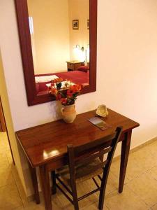 a table with a mirror and a vase with flowers on it at Agriturismo Le Frasche in Alberese +37 photos