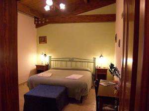a bedroom with a bed and two tables and two lamps at Agriturismo Le Frasche in Alberese
