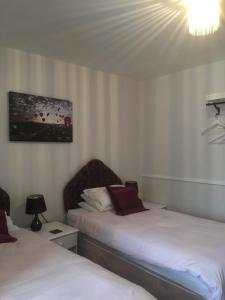 ein Hotelzimmer mit 2 Betten und einem Kronleuchter in der Unterkunft Lewinsdale Lodge in Weston-super-Mare