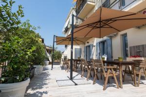 un patio con mesa, sillas y sombrilla en Guest House - Il Cedro Reale en Venaria Reale