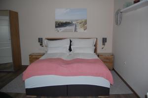 een slaapkamer met een groot bed met een schilderij aan de muur bij Weingut Krikler in Weiden am See