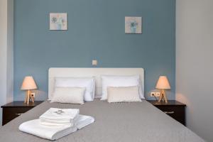 a blue bedroom with a large bed with two lamps at Villa Serenity in Agia Marina