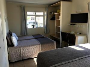 a hotel room with two beds and a window at Pousada Mar Do Leste in Florianópolis +52 photos