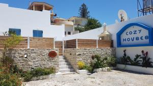 a building with a sign for a cozy house at Tanyas Cozy House in Kamilari