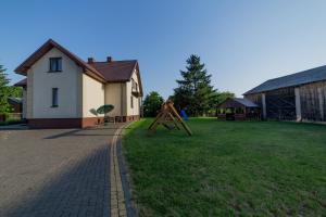 a large yard with a house and a playground at Agroturystyka Nowa Wólka in Łęczna