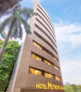 a hotel metropolitana building with a palm tree at Hotel Metropole Inn in Mumbai