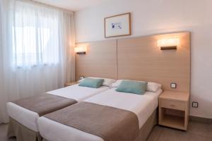 a hotel room with a bed and a lamp at Apartaments Cye Salou in Salou