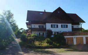 ein weißes Haus mit braunem Dach in der Unterkunft ruhig gelegene Allgäuer Ferienwohnung in Scheidegg