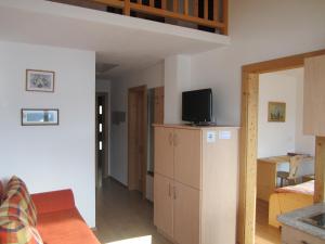 a living room with a tv on top of a cabinet at Pircherhof in San Candido