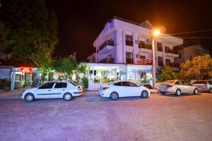 un groupe de voitures garées sur un parking la nuit dans l'établissement Lidya City Hotel, à Fethiye