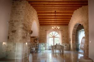 a dining room with a stone wall and a chandelier at Villa Santa Margherita in Chiaramonte Gulfi