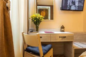 a desk with a vase of flowers and a mirror at Sofia Place Hotel by HMG in Sofia