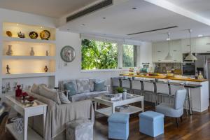 eine Küche und ein Wohnzimmer mit einem Sofa und einer Theke in der Unterkunft Larnaca Villa Marisol Kiti in Larnaka