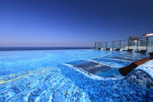 a large blue swimming pool with chairs in it at H Resort in Checheng