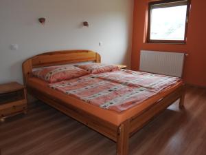 バダチョニトマイにあるPetra Apartmanházのベッドルーム1室(木製ベッド1台付)