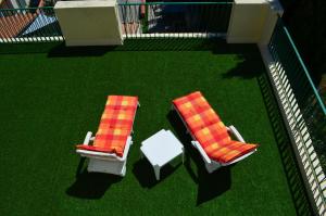 two chairs and a table on a lawn withgrass at L'Amandier in Maury